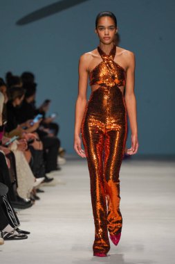 MİLAN, İTALYA - 24 Şubat 2022 'de Milano Moda Haftası / Kış 2023' te İtalya 'nın Milano kentinde düzenlenen Genny defilesinde bir model podyumda yürüyor..