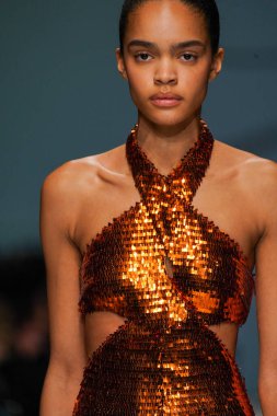 MİLAN, İTALYA - 24 Şubat 2022 'de Milano Moda Haftası / Kış 2023' te İtalya 'nın Milano kentinde düzenlenen Genny defilesinde bir model podyumda yürüyor..