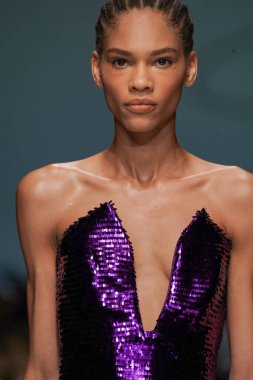 MİLAN, İTALYA - 24 Şubat 2022 'de Milano Moda Haftası / Kış 2023' te İtalya 'nın Milano kentinde düzenlenen Genny defilesinde bir model podyumda yürüyor..