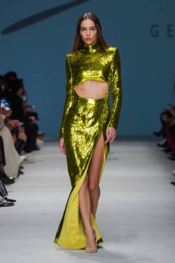 MİLAN, İTALYA - 24 Şubat 2022 'de Milano Moda Haftası / Kış 2023' te İtalya 'nın Milano kentinde düzenlenen Genny defilesinde bir model podyumda yürüyor..