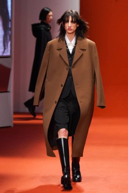 MILAN, İTALYA - 25 Şubat 2022 'de Milan Moda Haftası / Kış 2023' te İtalya 'nın Milano kentinde Tod defilesinde bir model podyumda yürüyor..