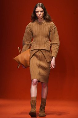 MILAN, İTALYA - 25 Şubat 2022 'de Milan Moda Haftası / Kış 2023' te İtalya 'nın Milano kentinde Tod defilesinde bir model podyumda yürüyor..