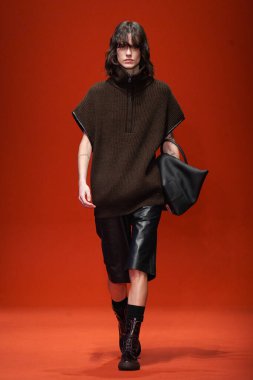 MILAN, İTALYA - 25 Şubat 2022 'de Milan Moda Haftası / Kış 2023' te İtalya 'nın Milano kentinde Tod defilesinde bir model podyumda yürüyor..