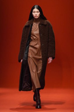 MILAN, İTALYA - 25 Şubat 2022 'de Milan Moda Haftası / Kış 2023' te İtalya 'nın Milano kentinde Tod defilesinde bir model podyumda yürüyor..