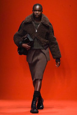 MILAN, İTALYA - 25 Şubat 2022 'de Milan Moda Haftası / Kış 2023' te İtalya 'nın Milano kentinde Tod defilesinde bir model podyumda yürüyor..