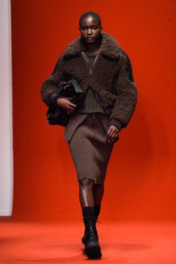 MILAN, İTALYA - 25 Şubat 2022 'de Milan Moda Haftası / Kış 2023' te İtalya 'nın Milano kentinde Tod defilesinde bir model podyumda yürüyor..