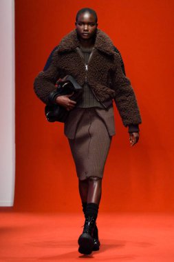 MILAN, İTALYA - 25 Şubat 2022 'de Milan Moda Haftası / Kış 2023' te İtalya 'nın Milano kentinde Tod defilesinde bir model podyumda yürüyor..