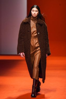 MILAN, İTALYA - 25 Şubat 2022 'de Milan Moda Haftası / Kış 2023' te İtalya 'nın Milano kentinde Tod defilesinde bir model podyumda yürüyor..