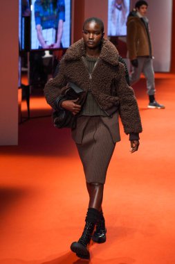 MILAN, İTALYA - 25 Şubat 2022 'de Milan Moda Haftası / Kış 2023' te İtalya 'nın Milano kentinde Tod defilesinde bir model podyumda yürüyor..