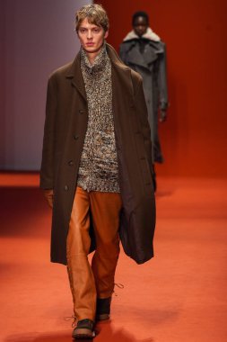 MILAN, İTALYA - 25 Şubat 2022 'de Milan Moda Haftası / Kış 2023' te İtalya 'nın Milano kentinde Tod defilesinde bir model podyumda yürüyor..