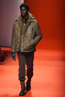 MILAN, İTALYA - 25 Şubat 2022 'de Milan Moda Haftası / Kış 2023' te İtalya 'nın Milano kentinde Tod defilesinde bir model podyumda yürüyor..