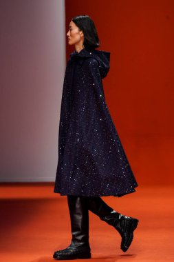 MILAN, İTALYA - 25 Şubat 2022 'de Milan Moda Haftası / Kış 2023' te İtalya 'nın Milano kentinde Tod defilesinde bir model podyumda yürüyor..