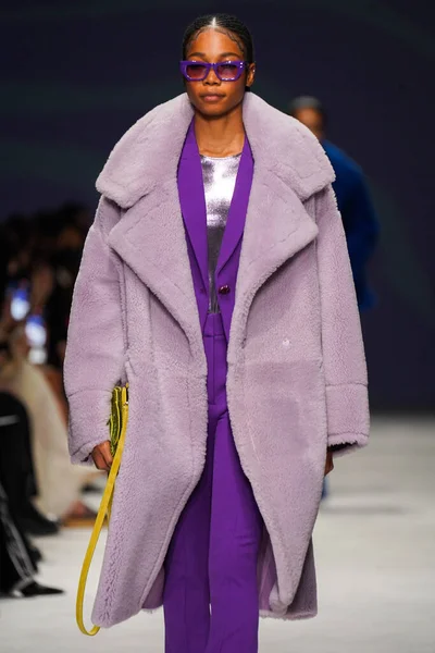 MİLAN, İTALYA - 24 Şubat 2022 'de Milano Moda Haftası / Kış 2023' te İtalya 'nın Milano kentinde düzenlenen Genny defilesinde bir model podyumda yürüyor..