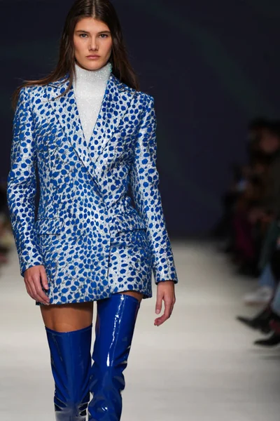 MİLAN, İTALYA - 24 Şubat 2022 'de Milano Moda Haftası / Kış 2023' te İtalya 'nın Milano kentinde düzenlenen Genny defilesinde bir model podyumda yürüyor..