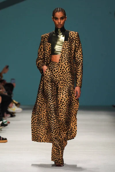 MİLAN, İTALYA - 24 Şubat 2022 'de Milano Moda Haftası / Kış 2023' te İtalya 'nın Milano kentinde düzenlenen Genny defilesinde bir model podyumda yürüyor..