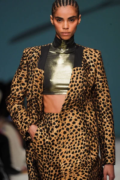 MİLAN, İTALYA - 24 Şubat 2022 'de Milano Moda Haftası / Kış 2023' te İtalya 'nın Milano kentinde düzenlenen Genny defilesinde bir model podyumda yürüyor..