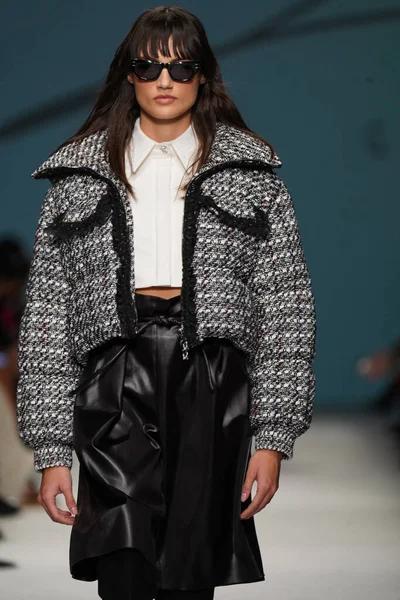 MİLAN, İTALYA - 24 Şubat 2022 'de Milano Moda Haftası / Kış 2023' te İtalya 'nın Milano kentinde düzenlenen Genny defilesinde bir model podyumda yürüyor..