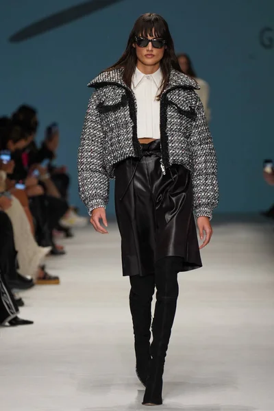 MİLAN, İTALYA - 24 Şubat 2022 'de Milano Moda Haftası / Kış 2023' te İtalya 'nın Milano kentinde düzenlenen Genny defilesinde bir model podyumda yürüyor..