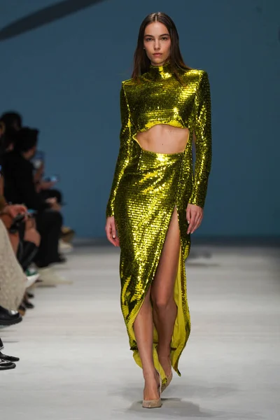 MİLAN, İTALYA - 24 Şubat 2022 'de Milano Moda Haftası / Kış 2023' te İtalya 'nın Milano kentinde düzenlenen Genny defilesinde bir model podyumda yürüyor..