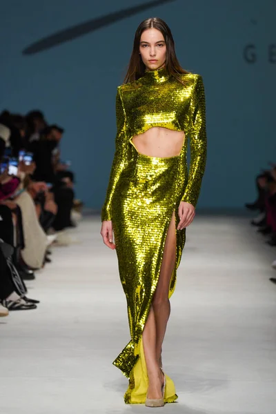 MİLAN, İTALYA - 24 Şubat 2022 'de Milano Moda Haftası / Kış 2023' te İtalya 'nın Milano kentinde düzenlenen Genny defilesinde bir model podyumda yürüyor..