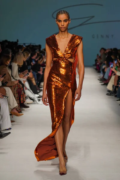 MİLAN, İTALYA - 24 Şubat 2022 'de Milano Moda Haftası / Kış 2023' te İtalya 'nın Milano kentinde düzenlenen Genny defilesinde bir model podyumda yürüyor..