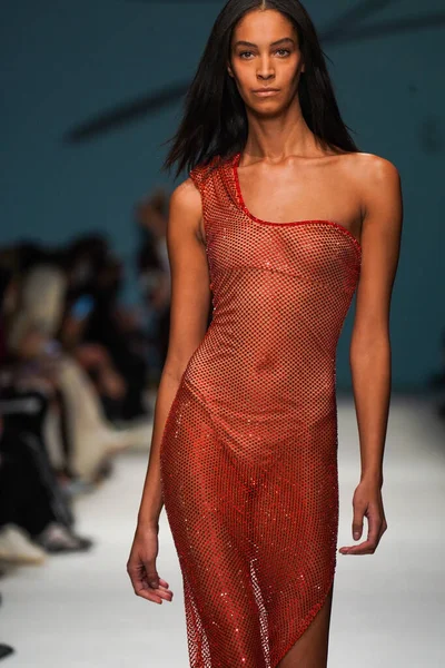 MİLAN, İTALYA - 24 Şubat 2022 'de Milano Moda Haftası / Kış 2023' te İtalya 'nın Milano kentinde düzenlenen Genny defilesinde bir model podyumda yürüyor..