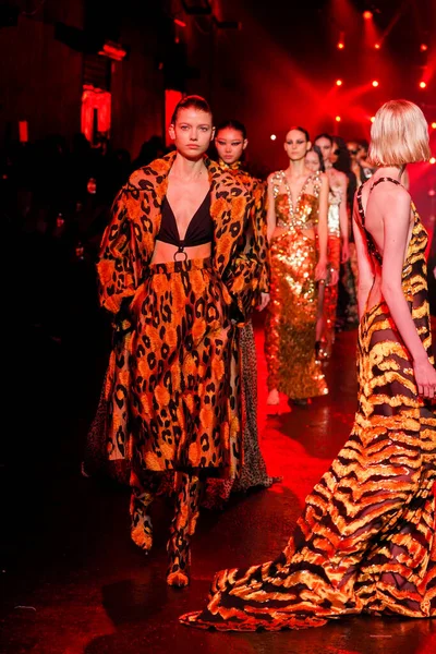 MİLAN, İTALYA 23 Şubat 2022 'de Milan Moda Haftası / Kış 2023' te İtalya 'nın Milano kentinde düzenlenen Roberto Cavalli defilesinde mankenler podyum finalinde yürür..