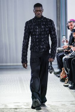 MILAN, ITALY - 26 Şubat 2022 'de Milano Moda Haftası / Kış 2023' te İtalya 'nın Milano kentinde düzenlenen Trussardi defilesinde bir model podyumda yürüyor..