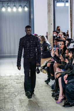 MILAN, ITALY - 26 Şubat 2022 'de Milano Moda Haftası / Kış 2023' te İtalya 'nın Milano kentinde düzenlenen Trussardi defilesinde bir model podyumda yürüyor..