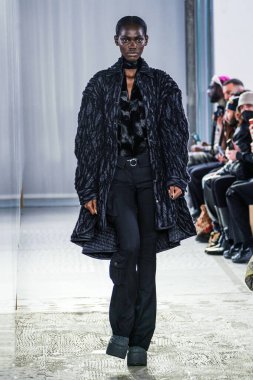 MILAN, ITALY - 26 Şubat 2022 'de Milano Moda Haftası / Kış 2023' te İtalya 'nın Milano kentinde düzenlenen Trussardi defilesinde bir model podyumda yürüyor..