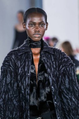 MILAN, ITALY - 26 Şubat 2022 'de Milano Moda Haftası / Kış 2023' te İtalya 'nın Milano kentinde düzenlenen Trussardi defilesinde bir model podyumda yürüyor..