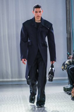 MILAN, ITALY - 26 Şubat 2022 'de Milano Moda Haftası / Kış 2023' te İtalya 'nın Milano kentinde düzenlenen Trussardi defilesinde bir model podyumda yürüyor..