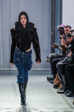 MILAN, ITALY - 26 Şubat 2022 'de Milano Moda Haftası / Kış 2023' te İtalya 'nın Milano kentinde düzenlenen Trussardi defilesinde bir model podyumda yürüyor..