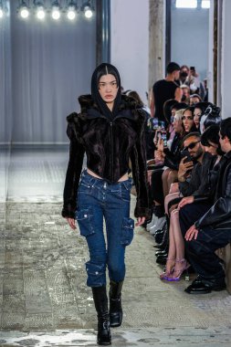 MILAN, ITALY - 26 Şubat 2022 'de Milano Moda Haftası / Kış 2023' te İtalya 'nın Milano kentinde düzenlenen Trussardi defilesinde bir model podyumda yürüyor..