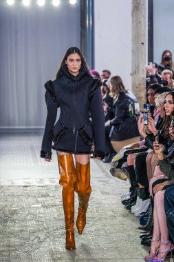 MILAN, ITALY - 26 Şubat 2022 'de Milano Moda Haftası / Kış 2023' te İtalya 'nın Milano kentinde düzenlenen Trussardi defilesinde bir model podyumda yürüyor..