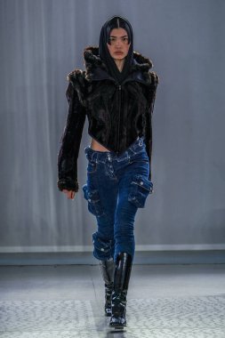 MILAN, ITALY - 26 Şubat 2022 'de Milano Moda Haftası / Kış 2023' te İtalya 'nın Milano kentinde düzenlenen Trussardi defilesinde bir model podyumda yürüyor..