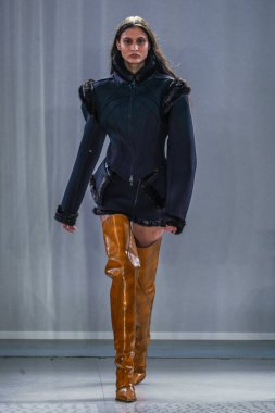 MILAN, ITALY - 26 Şubat 2022 'de Milano Moda Haftası / Kış 2023' te İtalya 'nın Milano kentinde düzenlenen Trussardi defilesinde bir model podyumda yürüyor..