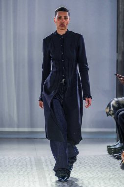 MILAN, ITALY - 26 Şubat 2022 'de Milano Moda Haftası / Kış 2023' te İtalya 'nın Milano kentinde düzenlenen Trussardi defilesinde bir model podyumda yürüyor..