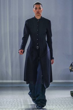 MILAN, ITALY - 26 Şubat 2022 'de Milano Moda Haftası / Kış 2023' te İtalya 'nın Milano kentinde düzenlenen Trussardi defilesinde bir model podyumda yürüyor..