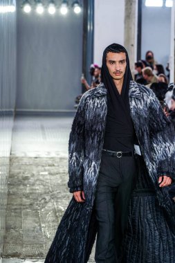 MILAN, ITALY - 26 Şubat 2022 'de Milano Moda Haftası / Kış 2023' te İtalya 'nın Milano kentinde düzenlenen Trussardi defilesinde bir model podyumda yürüyor..