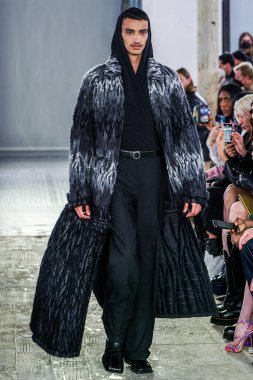 MILAN, ITALY - 26 Şubat 2022 'de Milano Moda Haftası / Kış 2023' te İtalya 'nın Milano kentinde düzenlenen Trussardi defilesinde bir model podyumda yürüyor..