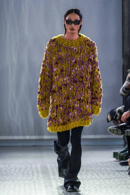 MILAN, ITALY - 26 Şubat 2022 'de Milano Moda Haftası / Kış 2023' te İtalya 'nın Milano kentinde düzenlenen Trussardi defilesinde bir model podyumda yürüyor..