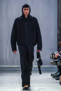 MILAN, ITALY - 26 Şubat 2022 'de Milano Moda Haftası / Kış 2023' te İtalya 'nın Milano kentinde düzenlenen Trussardi defilesinde bir model podyumda yürüyor..