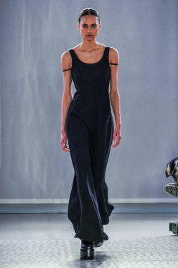 MILAN, ITALY - 26 Şubat 2022 'de Milano Moda Haftası / Kış 2023' te İtalya 'nın Milano kentinde düzenlenen Trussardi defilesinde bir model podyumda yürüyor..