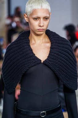 MILAN, ITALY - 26 Şubat 2022 'de Milano Moda Haftası / Kış 2023' te İtalya 'nın Milano kentinde düzenlenen Trussardi defilesinde bir model podyumda yürüyor..