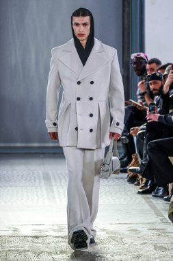 MILAN, ITALY - 26 Şubat 2022 'de Milano Moda Haftası / Kış 2023' te İtalya 'nın Milano kentinde düzenlenen Trussardi defilesinde bir model podyumda yürüyor..