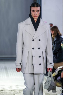 MILAN, ITALY - 26 Şubat 2022 'de Milano Moda Haftası / Kış 2023' te İtalya 'nın Milano kentinde düzenlenen Trussardi defilesinde bir model podyumda yürüyor..