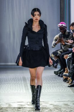 MILAN, ITALY - 26 Şubat 2022 'de Milano Moda Haftası / Kış 2023' te İtalya 'nın Milano kentinde düzenlenen Trussardi defilesinde bir model podyumda yürüyor..