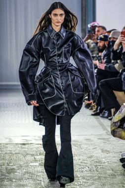 MILAN, ITALY - 26 Şubat 2022 'de Milano Moda Haftası / Kış 2023' te İtalya 'nın Milano kentinde düzenlenen Trussardi defilesinde bir model podyumda yürüyor..