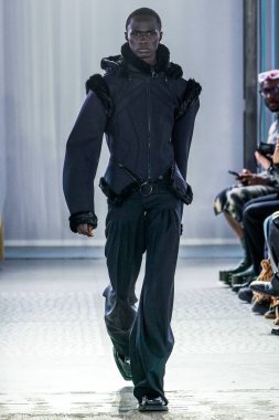 MILAN, ITALY - 26 Şubat 2022 'de Milano Moda Haftası / Kış 2023' te İtalya 'nın Milano kentinde düzenlenen Trussardi defilesinde bir model podyumda yürüyor..